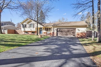 Split level home with brick siding, driveway, and an attached garage