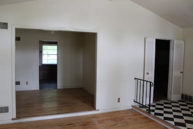 Hall with baseboards, vaulted ceiling, wood finish