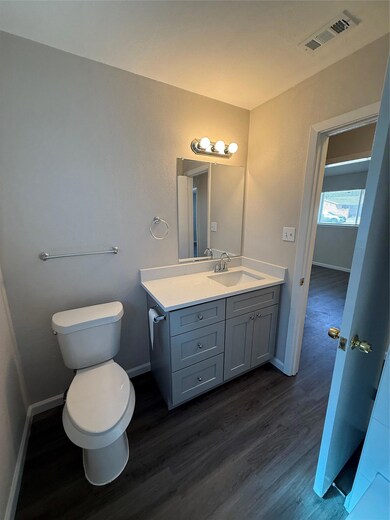 Half bath with visible vents, baseboards, toilet,