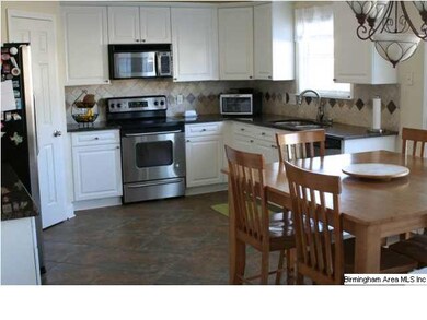 Crisp, clean kitchen with many cupboards and a lar