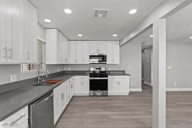 Kitchen with white cabinets, a sink, stainless ste