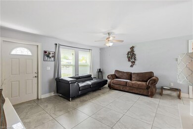 Living room featuring ceiling fan and light tile p