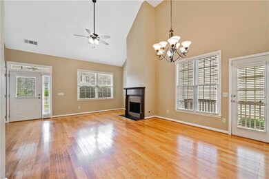 Unfurnished living room with high vaulted ceiling, a chandelier, healthy amount of natural light, ceiling fan, and light wood finished floors