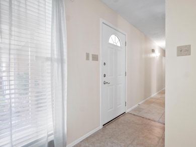 Foyer with light tile patterned floors and basebo