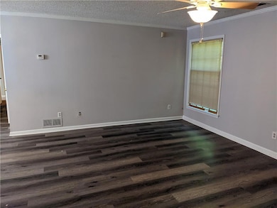 Spare room with dark hardwood / wood-style flooring, ceiling fan, and a textured ceiling