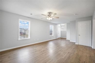 Unfurnished living room featuring light wood-style floors and a ceiling fan
