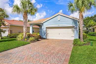 Mediterranean / spanish home featuring stucco siding, an attached garage, decorative driveway, a front lawn, and a tile roof