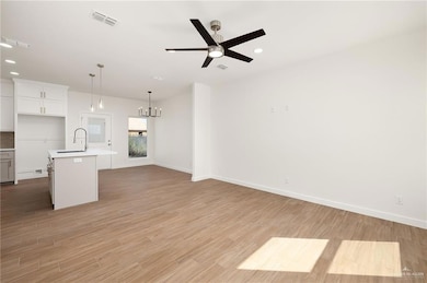 Unfurnished living room featuring recessed lighting, light wood-style flooring, a chandelier, and ceiling fan