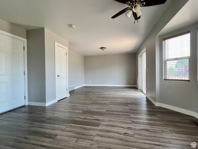 Unfurnished bedroom featuring wood finished floors, ceiling fan, and access to exterior