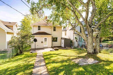 Rear view of property with a lawn, an outbuilding,