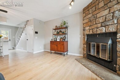 Living room with baseboards, wood finished floors, stairway, and a fireplace