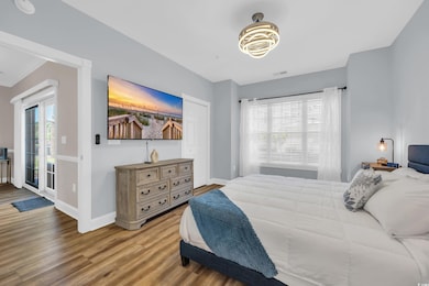 Bedroom with wood finished floors and access to outside