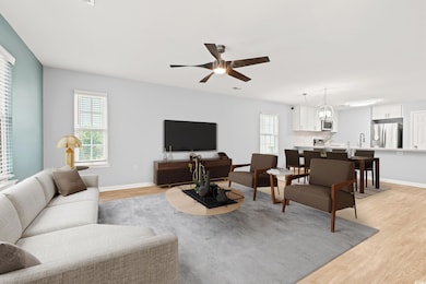 Living room featuring light wood-style flooring, plenty of natural light, ceiling fan, and baseboards