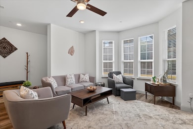 Living area with wood finished floors, ceiling fan, and recessed lighting
