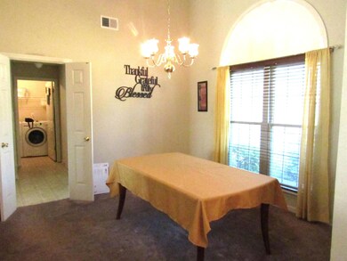 Dining room featuring washer / dryer, healthy amount of natural light, and a chandelier