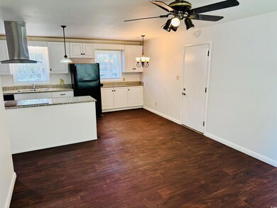 Kitchen featuring island range hood, dark wood-sty