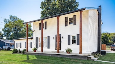 View of front of home featuring a chimney, a front yard, and a porch