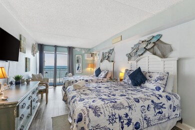 Bedroom with expansive windows, a textured ceiling, access to exterior, wood finished floors, and a wall mounted AC