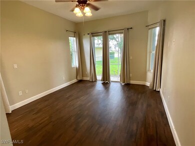 Empty room with dark wood-type flooring and a ceiling fan