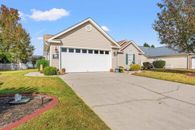 Ranch-style house featuring a front lawn and a gar