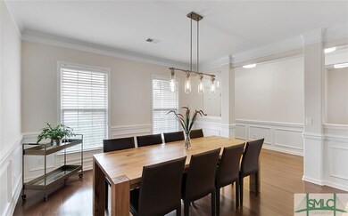 Formal dining room with wood floors, crown molding