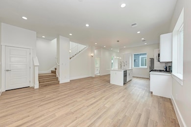 Unfurnished living room featuring stairway, light
