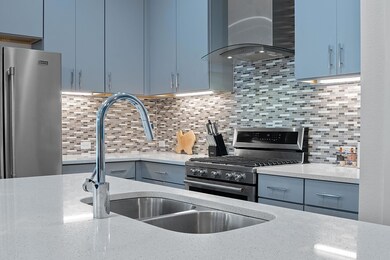 Kitchen with light stone counters, appliances wit