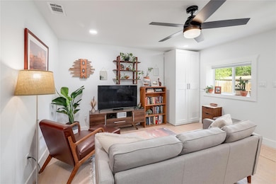 Living room with visible vents, ceiling fan, rece