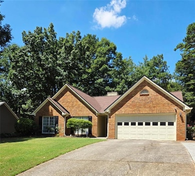 Ranch-style house featuring an attached garage, driveway, a front lawn, brick siding, and a chimney