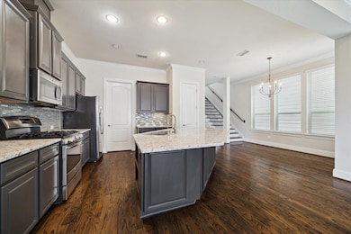 Modern kitchen with dark cabinetry, stainless stee