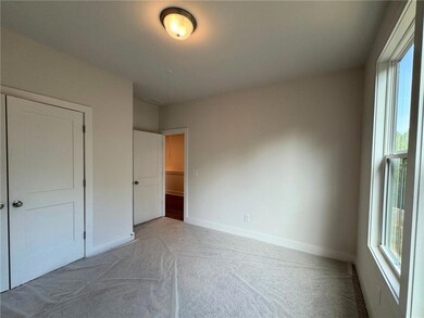 Unfurnished bedroom featuring light colored carpet and baseboards