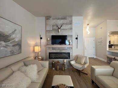Living area featuring a glass covered fireplace, b