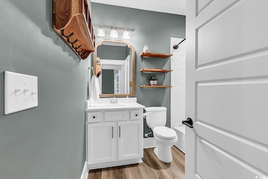 Bathroom with vanity, toilet, wood finished floors, and  shower combination