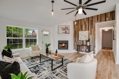 Living area with a warm lit fireplace, wood walls