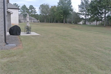 View of large backyard space with patio area
