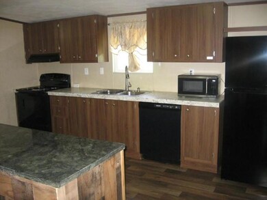 Kitchen with black appliances, a sink, dark wood-