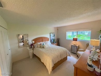 Bedroom with a textured ceiling and carpet floors