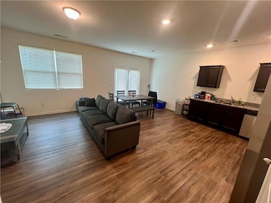 Living area with dark wood finished floors, basebo