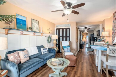 Living room featuring dark wood-type flooring and a ceiling fan