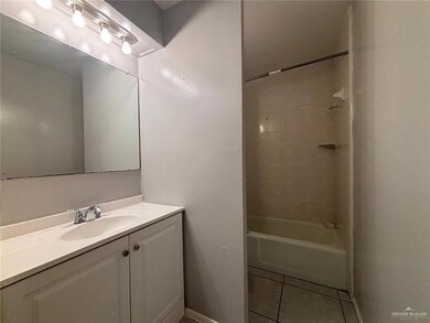 Bathroom featuring vanity, shower / tub combination, tile patterned flooring, and baseboards