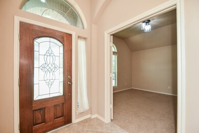 This is your beautiful front entrance from the inside foyer. Note the arched doorway theme and the palest earth shades on the walls. This room, right, with classic french doors, is the perfect spot for a private study or home office. Tile flooring in the entry and carpet in the study.