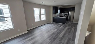 Kitchen featuring dark cabinets, stainless steel a