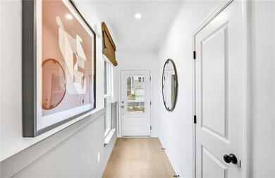 Entryway with light wood-style flooring, recessed lighting, and ornamental molding