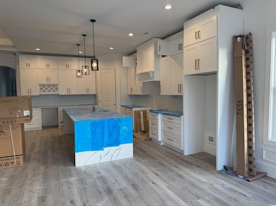 Kitchen with a center island with sink, sink, ligh