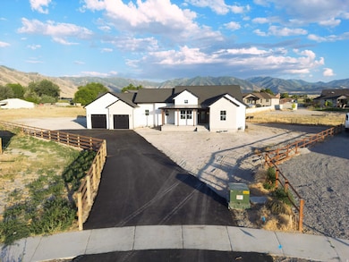 Modern farmhouse with a mountain view, driveway, and stucco siding