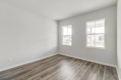 Empty room with a healthy amount of sunlight, baseboards, and dark wood finished floors