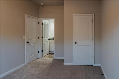 Unfurnished bedroom featuring light colored carpet and ensuite bath
