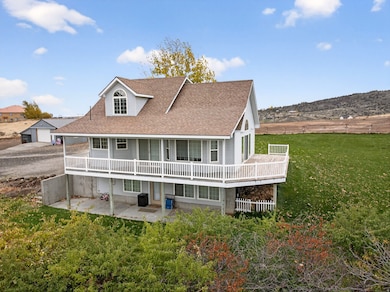 Rear view of property featuring a yard, a patio area, a shingled roof, and a deck