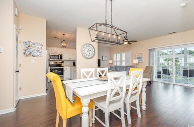 Dining room with ceiling fan with notable chandeli