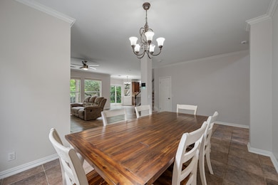Dining space with a chandelier, baseboards, a cei